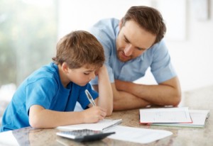 Ilustrasjon: Photos.com. Mann som hjelper sønnen med leksene