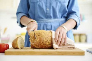 kvinne skjærer brød